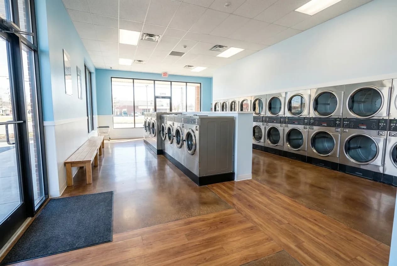 Bright open laundromat interior with clear sightlines and simple seating